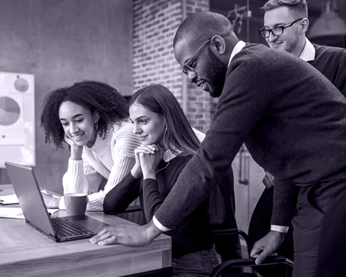 A team gathered around a laptop during a working session