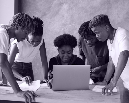A team reviewing printed plans and a laptop around a table
